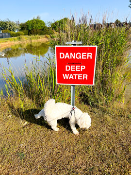 A red warning sign warns people of deep water