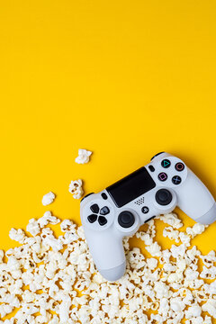 August 26, 2026, Odessa, Ukraine.  White Sony PS4 DualShock controller with popcorn on bright yellow back