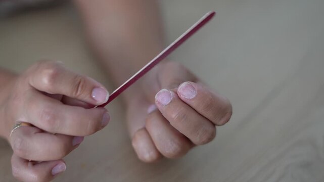 Close Up of Hands Filing Fingernails With a Nail File