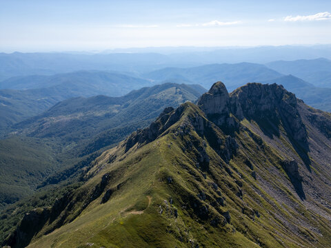 Aerial view of Parco Nazionale dell'Appennino Tosco-Emiliano featuring rugged mountain ridges, grassy slopes, and rocky peaks in Provincia di Massa e, Italy.
