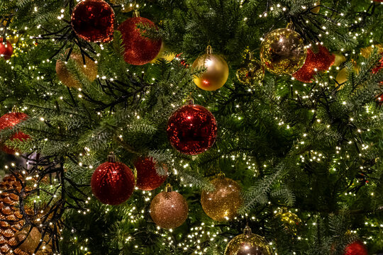 sparkling lights on a Christmas tree with red and gold  balls, selective focus. Christmas tree background with festive garland