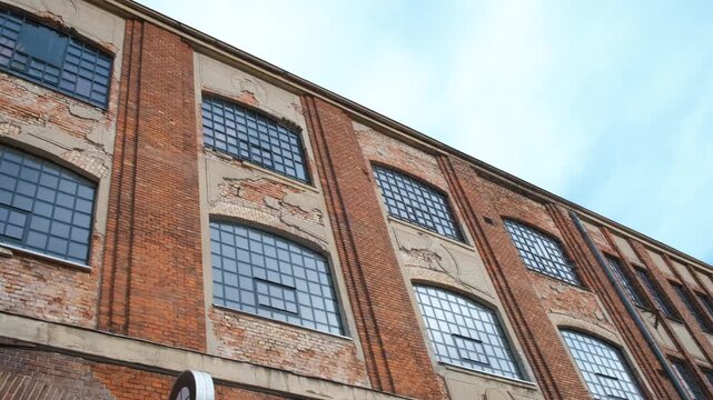 One abandoned brick building in day. A view of lonely brick building with old fasade in the day time