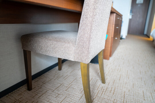 Low angle view of a desk and upholstered chair at a hotel room