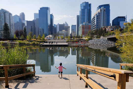 Young boy admiring the landscape by the Bow River in downtown Calgary on a warm sunny day