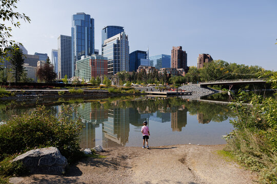 Young boy standing by the Bow River in downtown Calgary on a warm summer day