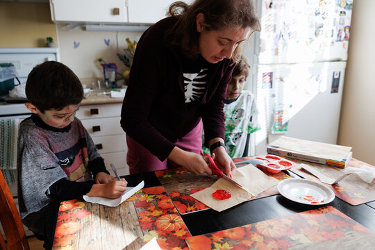 Woman and children preparing sweet jelly treats for Halloween