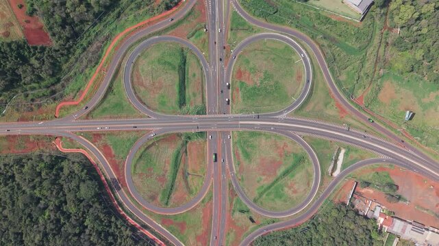 Intercambiador vial tipo tr&eacute;bol con entradas y salidas de autopista, vista cenital a&eacute;rea captada con dron