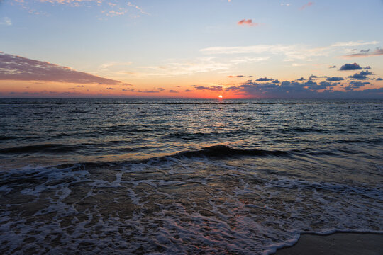 Sun rising over the horizon at a beach in the Riviera Maya in Mexico