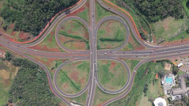 Intercambiador vial tipo tr&eacute;bol con entradas y salidas de autopista, vista cenital a&eacute;rea captada con dron