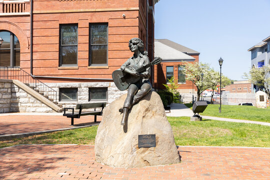 Sevierville, TN, USA - April 13, 2025: Dolly Parton's statue outside of the Sevier County Courthouse. The building was opened in 1895 and is on the National Register of Historic Places. 