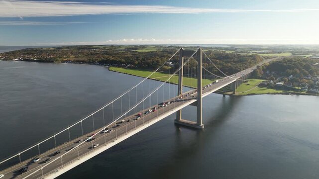 Aerial footage of the New Little Belt suspension bridge crossing calm blue water between Jutland and Funen near Middelfart and Fredericia, Denmark.