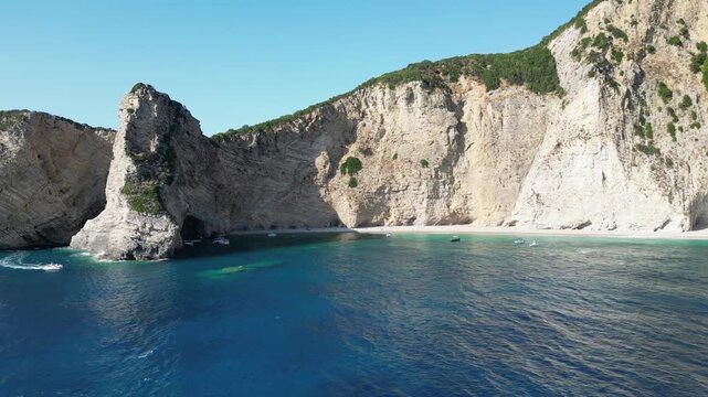 Aerial forward motion showing turquoise water and limestone cliffs at Chomi Beach in Corfu near Paleokastritsa