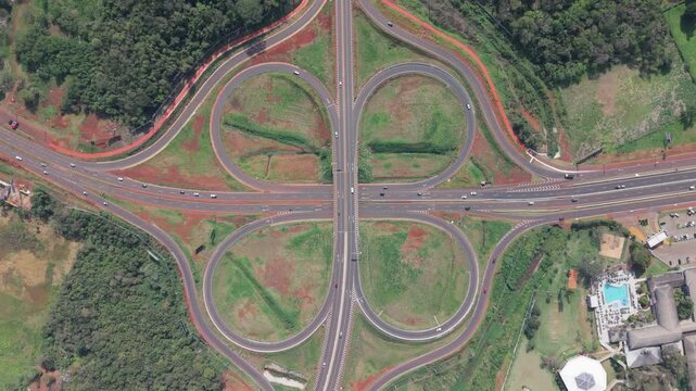 Intercambiador vial tipo tr&eacute;bol con entradas y salidas de autopista, vista cenital a&eacute;rea captada con dron