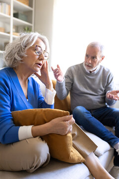 Senior couple having relationship problems arguing on sofa at home