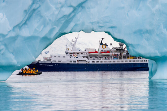 Cuverville Island, Antarctic Peninsula - January 31, 2024. Antarctic expedition ship the ocean adventurer is anchored near Cuverville Island on the Antarctic peninsula and framed by an iceberg in the
