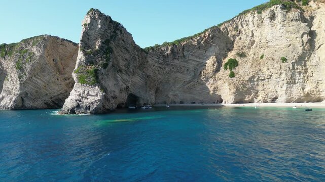 4K Aerial forward motion over Chomi Beach with turquoise sea and limestone cliffs in Corfu, Greece