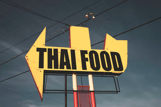 Aged and worn Thai food sign and arrow