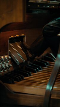 Feet playing the organ pedals of a large cathedral in Paris