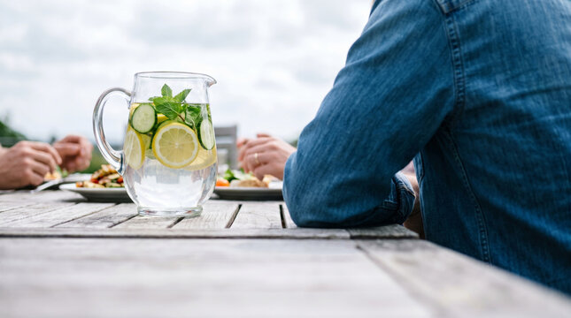 Refreshing infused water with lemon cucumber and mint served at an outdoor meal