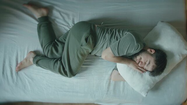 Young Man Sleeping In Fetal Position On Bed, Peaceful Rest At Home
