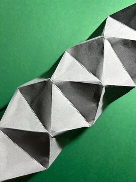 Geometric origami 3D triangle pattern on vibrant green paper background