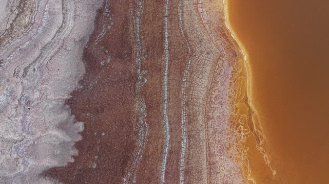 Aerial view of salt formations and orange water at the Dead Sea in South District, Israel.