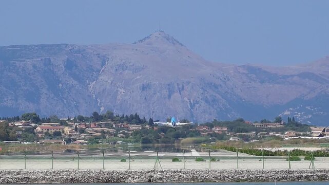 Telephoto shot showing TUI plane taking off at Corfu Airport with mountain backdrop