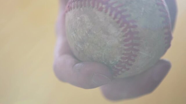 Hand holding dirty old baseball slow motion
