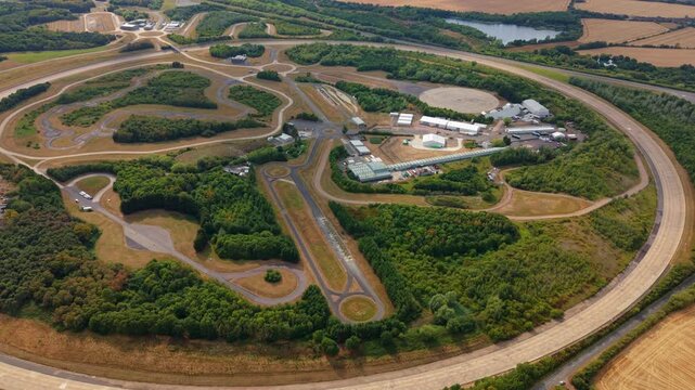 Aerial view of Millbrook Proving Ground with its extensive test tracks, asphalt circuits, and surrounding woodland in Bedford, England, United Kingdom.