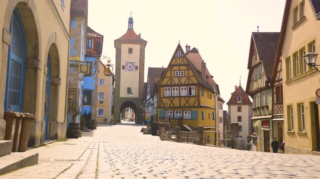 4K footage of a historic cobblestone street in Rothenburg ob der Tauber, Germany, featuring traditional half-timbered houses, medieval towers and preserved European architecture.