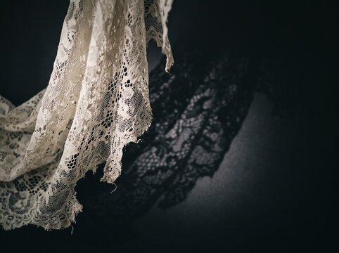 Torn Antique Lace Veil on Dark Background
