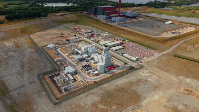 Aerial view of Millbrook Power Plant with industrial infrastructure, storage tanks, and surrounding open fields in Stewartby, England, United Kingdom.