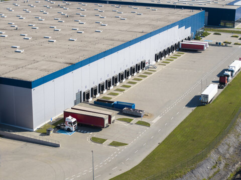 Aerial view of an e-commerce logistics terminal with parked semi-trailers and loading docks in Poland.