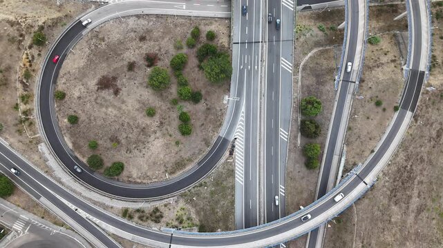 Aerial view of A5 highway interchange with vehicles driving on curved ramps and lanes in Cascais, Lisboa, Portugal.