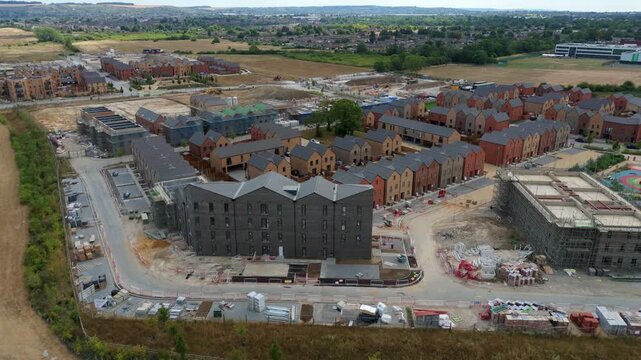 Aerial view of new housing development with brick houses and construction site in Luton, England, United Kingdom.