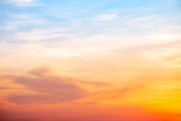 Fototapeta premium Sunset or sunrise sky with a vibrant gradient of orange, gold, and soft blue. Clear atmosphere with wispy clouds. Peaceful, natural light background. hope, freedom, new day and inspirational Concepts