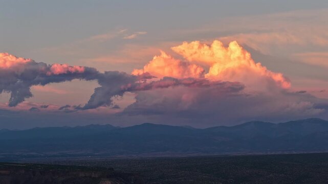 Aerial view of dramatic southwestern clouds shifting with radiant colors over the Sangre de Cristo range in Santa Fe, New Mexico, United States.