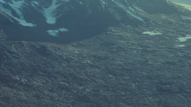 Aerial view of a rugged mountain landscape with patches of snow. Bright daylight shows the rocky terrain and scattered clouds. This scene captures the natural beauty of the area.