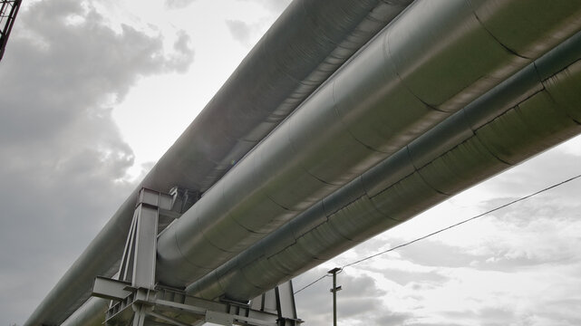 The photo shows a pipeline against a gray sk