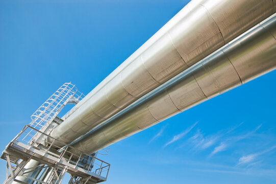 The photo shows a pipeline against a blue sky