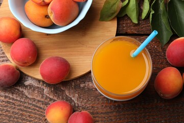 Apricot juice in glass, fresh fruits and leaves on wooden table, flat lay © New Africa