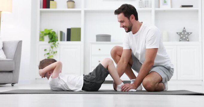 Father helping his son to do exercise at home