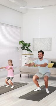 Father and his daughter doing exercise together at home