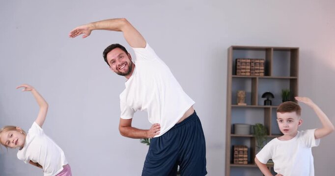 Father and his kids doing exercise together at home
