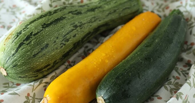 Many fresh raw zucchinis on table, closeup. Camera zooming in