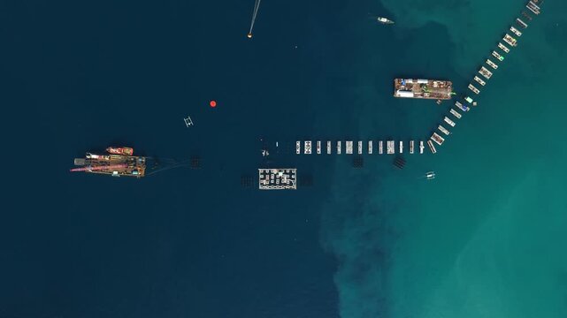 Aerial view of Fuel Oil Terminal construction with barges and concrete structures in the sea in Manggis, Bali, Indonesia.