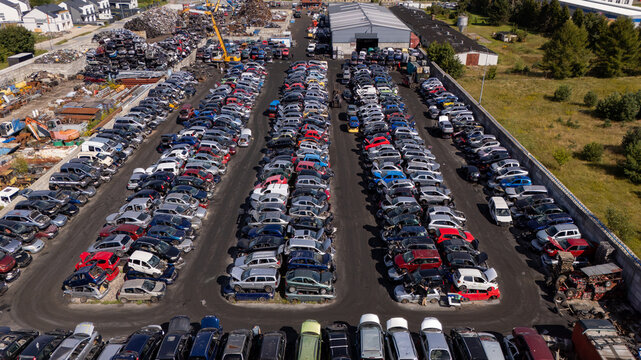 Aerial view of a large scrapyard filled with rows of salvaged cars and vehicle parts in Gdansk, Poland.