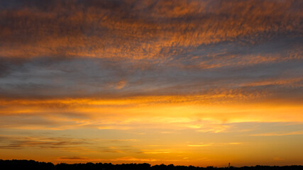 Fototapeta premium Golden sunset beneath dramatic textured clouds over the St. Louis skyline