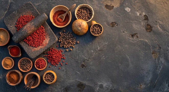 Overhead flat lay of Yucatan Annatto Achiote seeds and allspice on cenote stone