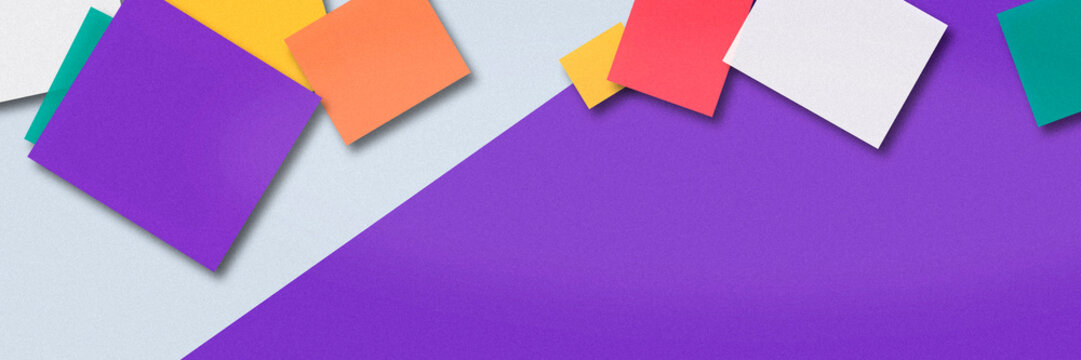 A dynamic cluster of purple and multicolor paper cards is scattered along a diagonal gray field, offering a vibrant, upbeat background for creative designs.